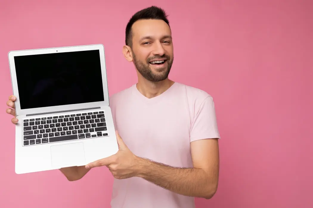 serwis MacBook — uśmiechnięty brunet trzyma laptopa