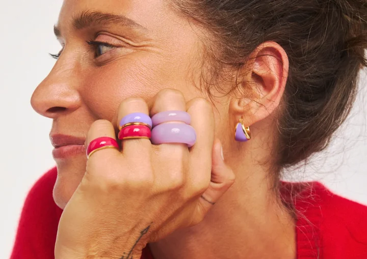 Zdjęcie przedstawia kobietę która prezentuje biżuterię (pierścionki i kolczyki)