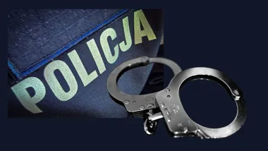 Fragment policyjnego munduru z napisem POLICJA oraz metalowe kajdanki na ciemnym tle.