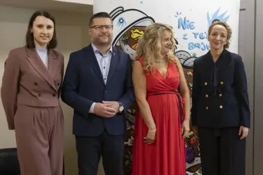 Cztery osoby pozują do zdjęcia przed kolorową ścianką z napisem „Nie z tej bajki”.