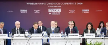 Uczestnicy oficjalnego panelu podczas Warszawskiej Konferencji Wymiaru Ludzkiego OSCE 2026 siedzą przy stole z mikrofonami i tabliczkami z nazwami stanowisk.