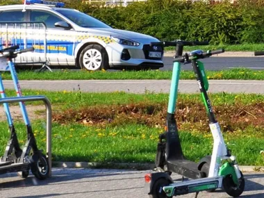 Dwoje dzieci pędziło na hulajnogach, jedno jechało na jednym kole